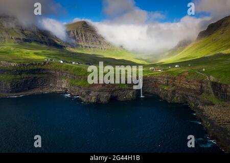 Cascade de Múlafossur avec village de Gásadalur sur l'île de Vagar, îles Féroé Banque D'Images