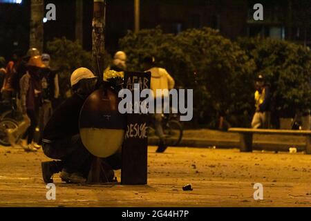 Bogota, Colombie. 17 juin 2021. Des membres de la ligne de front avec des boucliers avec le drapeau colombien se tiennent devant les manifestants tandis que les actes culturels et les manifestations se sont intensifiés plus tard dans la nuit à des affrontements entre manifestants et la police anti-émeute colombienne (ESMAD) protestent contre le président Ivan Duque, le 17 juin 2021 à Bogota, en Colombie. Crédit : long Visual Press/Alamy Live News Banque D'Images