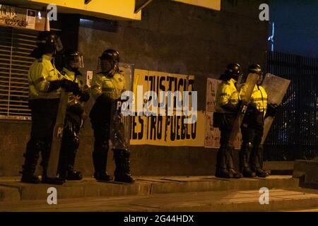 Bogota, Colombie. 17 juin 2021. Les policiers anti-émeutes de Colombie (ESMAD) se tiennent devant un panneau qui indique « Justice au peuple », tandis que les manifestations et actes culturels se sont intensifiés plus tard dans la nuit pour des affrontements entre manifestants et police anti-émeute de Colombie (ESMAD), une protestation admiste contre le gouvernement contre le président Ivan Duque, le 17 juin 2021 à Bogota, en Colombie. Crédit : long Visual Press/Alamy Live News Banque D'Images