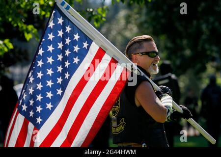 Portland, États-Unis. 18 juin 2021. Le policier « Flip » Todd, fier garçon, porte un drapeau. Une trentaine de fiers garçons, un groupe de haine national, ont organisé une « vague de drapeau » dans le parc rural de Clackamette, près de Portland, Oregon, le 18 juin 2021, et ont été confrontés à Antifa, un mouvement antifasciste ; une émeute a été rapidement déclarée après le début des combats. (Photo de John Rudoff/Sipa USA) crédit: SIPA USA/Alay Live News Banque D'Images