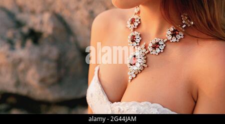 Grand collier brillant avec cristaux blancs et rouges sur la poitrine de la mariée, gros plan Banque D'Images