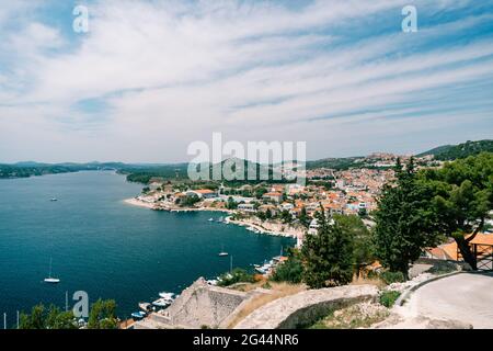 Vue sur la mer et la jetée avec des yachts blancs depuis l'arrière des toits des maisons anciennes de Sibenik. Vue latérale Banque D'Images