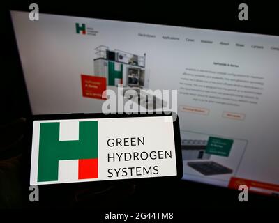 Personne tenant un téléphone portable avec le logo d'entreprise de la société danoise d'énergie Green Hydrogen Systems COMME à l'écran en face de la page Web. Mise au point sur l'affichage du téléphone. Banque D'Images