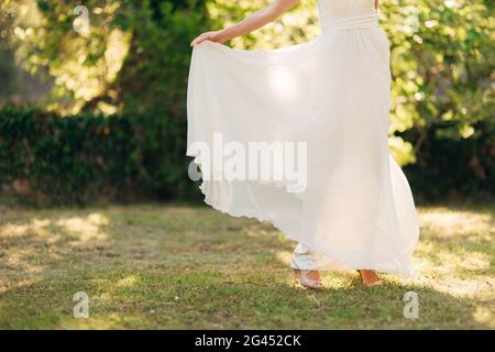 Belle Mariée heureuse à l'extérieur. Voletant de robe de mariage Banque D'Images