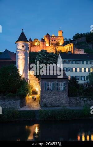 Le Tauber passe doucement le long de la vieille ville avec le Roter Turm am Faultor (Kittsteintor), la collégiale et le château de Wertheim au crépuscule, Wertheim, Spes Banque D'Images