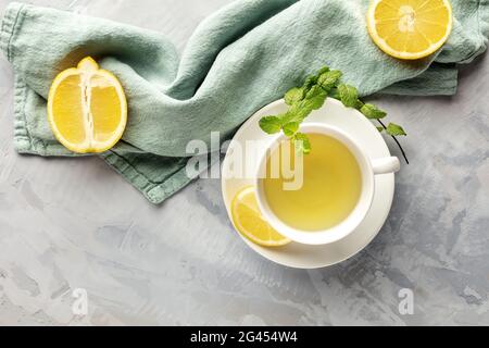 Photo aérienne d'une tasse de thé vert avec des citrons et des feuilles de menthe Banque D'Images