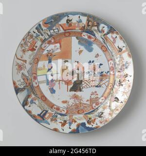 Plat avec des figures chinoises dans un jardin clos près d'un pavillon. Plat de porcelaine, peint en bleu sous-glaçure et sur le glaçure en bleu, rouge, rose, vert, jaune, noir et or. Sur l'appartement deux érudits à une table avec un serviteur dans un jardin clos à un pavillon; en outre, une dame avec un canow une table avec un vase de fleur, un vase avec des baguettes et un brûleur d'encens. Sur la droite une plante de pivoine et deux papillons. Sur le mur serviette de travail avec une fleur interrompue par une cartouche avec une branche de fleur. L'avantage avec une représentation continue des femmes et des enfants dans un intérieur ou un paysage dans le TH Banque D'Images