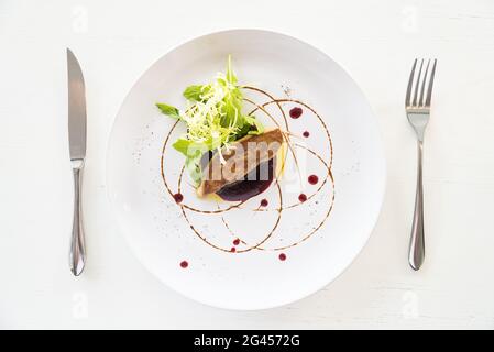 Foie gras grillé avec sauce douce dans un plat blanc - point de mire sélectif Banque D'Images