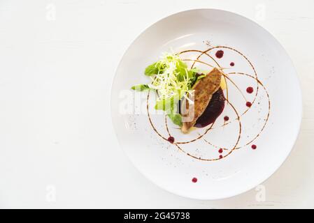 Foie gras grillé avec sauce douce dans un plat blanc - point de mire sélectif Banque D'Images