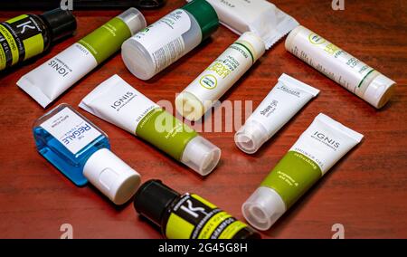 Un assortiment de produits de toilette de voyage de savon, gel douche, shampooing, lotion, mousse de bain, rasez le gel sur un fond en bois. Banque D'Images