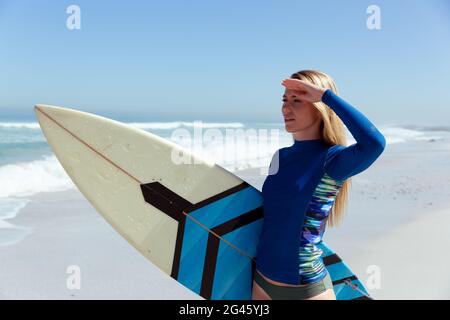 Femme caucasienne pendant la session de surf à la plage Banque D'Images