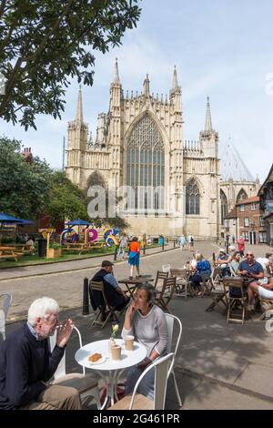 Les personnes qui mangent à l'extérieur avec York Minster en arrière-plan, City of York, Yorkshire, Angleterre, Royaume-Uni Banque D'Images