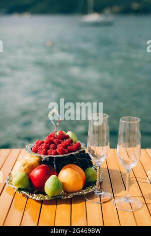 Plaque de deux étages avec des fruits : pommes, pêches, framboises, figues Banque D'Images