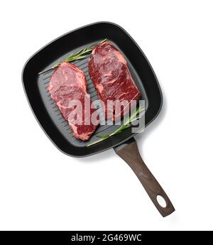 Deux morceaux de bœuf crus dans une poêle à grillades carrée noire, steaks isolés sur fond blanc Banque D'Images