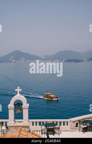 Budva, Monténégro - 13 juillet 2020 : un yacht de plaisance en bois navigue sur le fond de la ville de Budva. Clocher du chu Banque D'Images