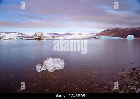 Le cube isolé de glace fondante s'est éloigné dans le lac glacier de Jokulsarlon, en Islande Banque D'Images