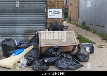 Les ordures sont laissées dans une rue urbaine, avec un panneau de non-basculement ou de non-vidage. Westcliff on Sea, Royaume-Uni Banque D'Images