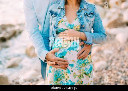 Pregnant woman holding belly with hands Banque D'Images