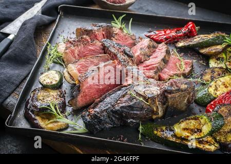 Barbecue traditionnel, steak de bœuf Wagyu vieilli et sec, servi avec du paprika et de l'aubergine sur un plateau métallique rustique Banque D'Images