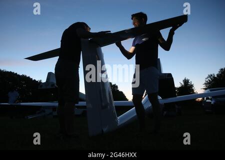 Düsseldorf, Allemagne. 19 juin 2021. Les membres du club de l'Aero Düsseldorf assemblent un ascenseur sur un planeur au champ de glisse Düsseldorf-Wolfsaap. Les pilotes de planeur voulaient prendre le soleil levant à partir de 4.30 heures pour saluer le plus long jour de l'année avec des « vols le plus long jour ». Crédit : David Young/dpa/Alay Live News Banque D'Images