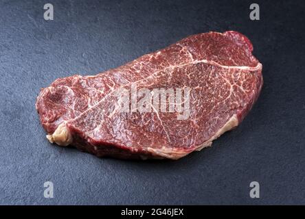 Filet traditionnel vieilli sec d'un steak de cheval naturel offert en gros plan sur un tableau noir avec espace de copie Banque D'Images