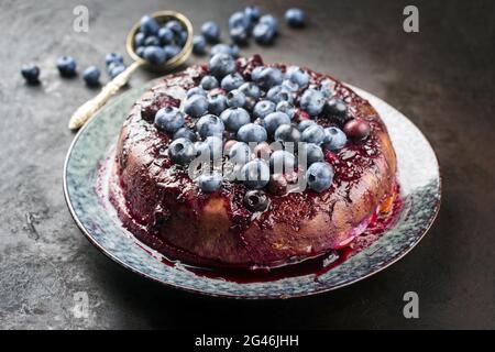 Tarte française traditionnelle aux myrtilles aux myrtilles aux myrtilles sucrées et à la vanille, proposée en gros plan sur une assiette design avec un blac rustique Banque D'Images