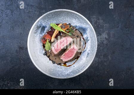 Tagliata di manzo italien de style moderne avec bifteck de sirloin en tranches d'âge sec et légumes à la sauce truffe servis comme le meilleur Banque D'Images