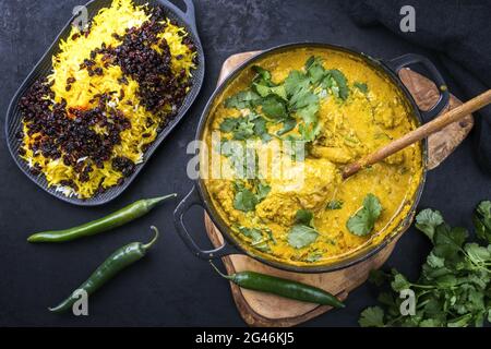 Masala traditionnel de poulet indien au curry avec riz au safran et berberis servi comme vue de dessus dans une casserole Banque D'Images