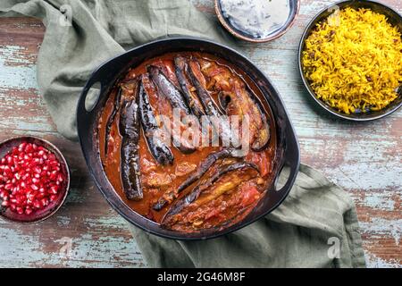 Un ragoût d'aubergines d'agneau persan lentement cuisiné de style moderne khoresh bademjan servi avec du riz et du yaourt comme vue de dessus dans un pot design Banque D'Images