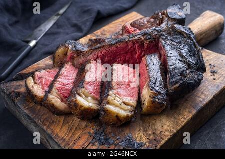 Barbecue traditionnel, hachée de bœuf Wagyu, steak bistecca alla Fiorentina coupé en tranches et servi avec du sel noir en gros plan Banque D'Images