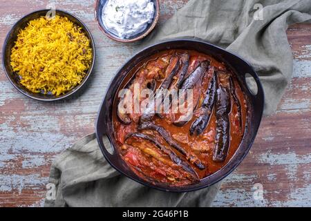 Un ragoût d'aubergines d'agneau persan lentement cuisiné de style moderne khoresh bademjan servi avec du riz et du yaourt comme vue de dessus dans un pot design Banque D'Images