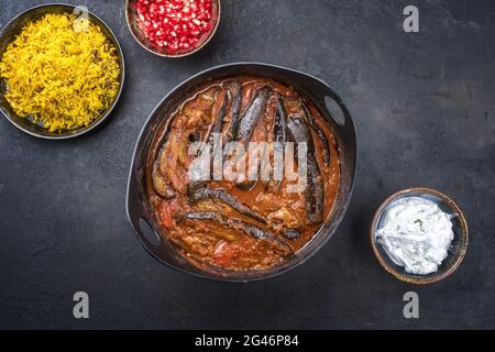 Un ragoût d'aubergines d'agneau persan lentement cuisiné de style moderne khoresh bademjan servi avec du riz et du yaourt comme vue de dessus dans un pot design Banque D'Images