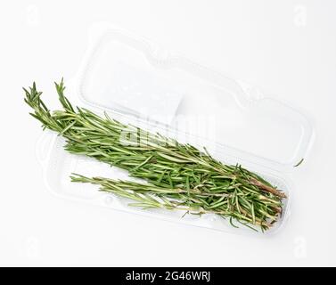 Brins de romarin frais dans un emballage en plastique transparent sur fond blanc Banque D'Images