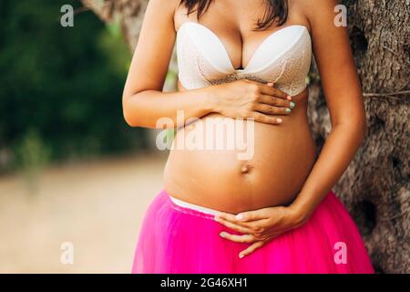 Pregnant woman holding belly with hands Banque D'Images