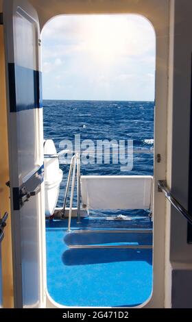 Vue sur le pont du navire, la mer bleue et le ciel par la porte ouverte. Concept de voyage Banque D'Images