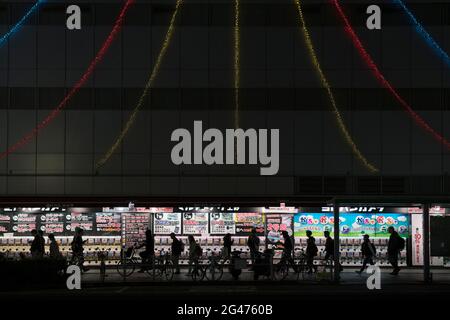 Les gens qui marchent devant une longue rangée de machines à gashaapon à Tokyo, au Japon Banque D'Images