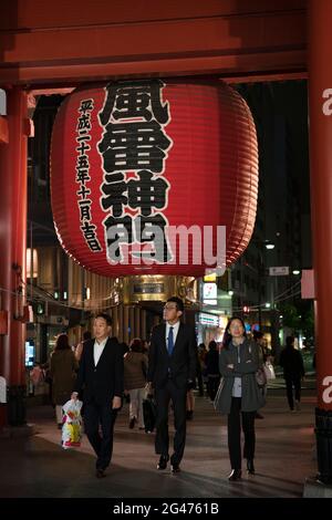 Personnes marchant sous une lanterne géante au Kaminarimon ('Thunder Gate') au temple Sensō-ji à Asakusa, Tokyo, Japon Banque D'Images