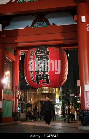 Personnes marchant sous une lanterne géante au Kaminarimon ('Thunder Gate') au temple Sensō-ji à Asakusa, Tokyo, Japon Banque D'Images