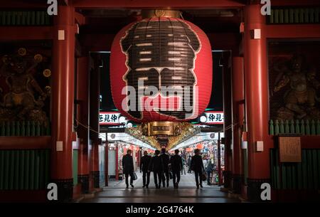 Personnes marchant sous une lanterne géante au Kaminarimon ('Thunder Gate') au temple Sensō-ji à Asakusa, Tokyo, Japon Banque D'Images