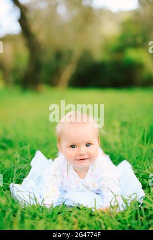 Portrait d'une adorable petite fille couché sur l'herbe dans le parc Banque D'Images