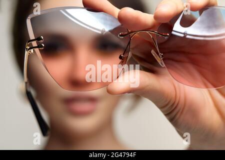 La femme regarde la caméra à travers des lunettes. Banque D'Images
