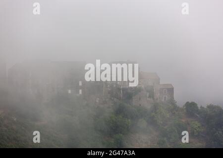 Village de montagne Corse noyé dans le brouillard. Région de Castagniccia, Corse, France Banque D'Images