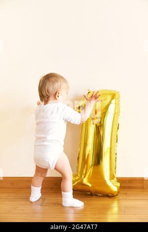 Petite fille se tient sur le sol dans la chambre près de la figure gonflable un Banque D'Images