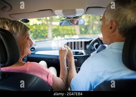 Couple senior aimant assis en voiture Banque D'Images