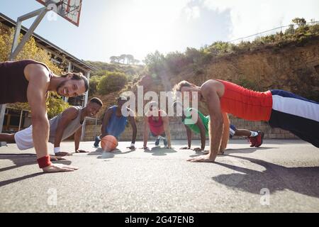 Les joueurs de basket-ball effectuent des exercices de poussée Banque D'Images