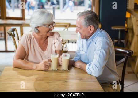 Heureux couple senior interagissant tout en prenant un café Banque D'Images