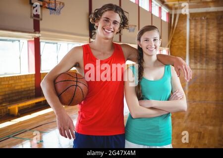 Portrait des joueurs de basket-ball debout avec le bras autour Banque D'Images