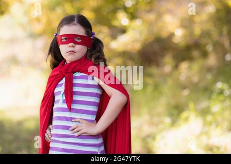 Petite fille portant le costume de super-héros au camping Banque D'Images