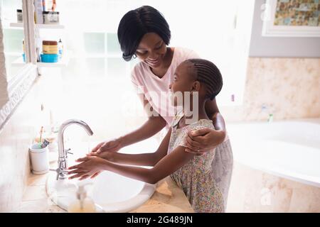 Mère et fille se lavant les mains dans le lavabo de la salle de bains Banque D'Images