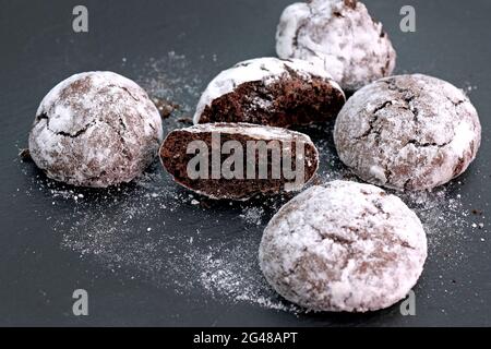 Biscuits aux pépites de chocolat saupoudrés de sucre en poudre. Biscuits ronds faits maison avec cacao et sucre en poudre sans gluten. Banque D'Images
